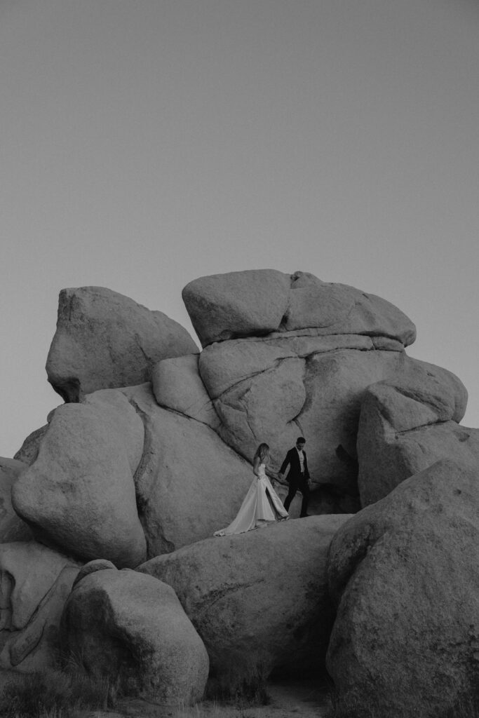 Black and white image of a couple during their elopement standing in front of boulders