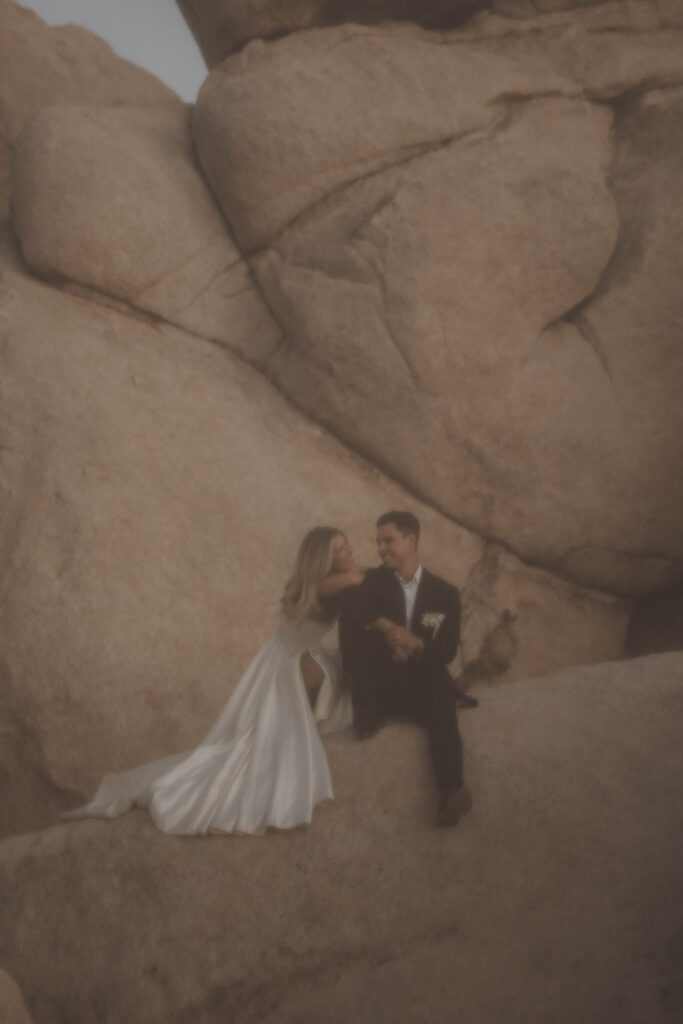 Couple in front of big boulders in Joshua Tree National Park