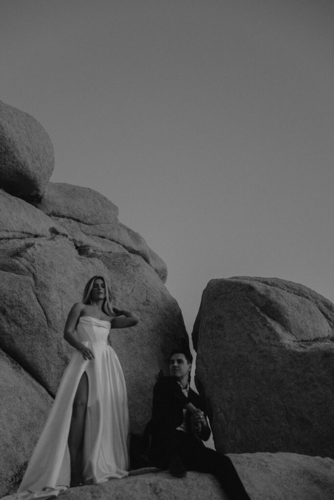 Black and white image of a couple during their elopement standing in front of boulders