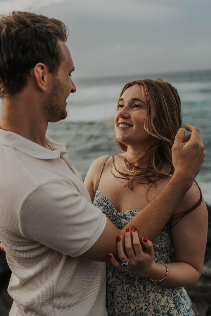 Couple looking at each other on a beach in Maui, Hawaii. 