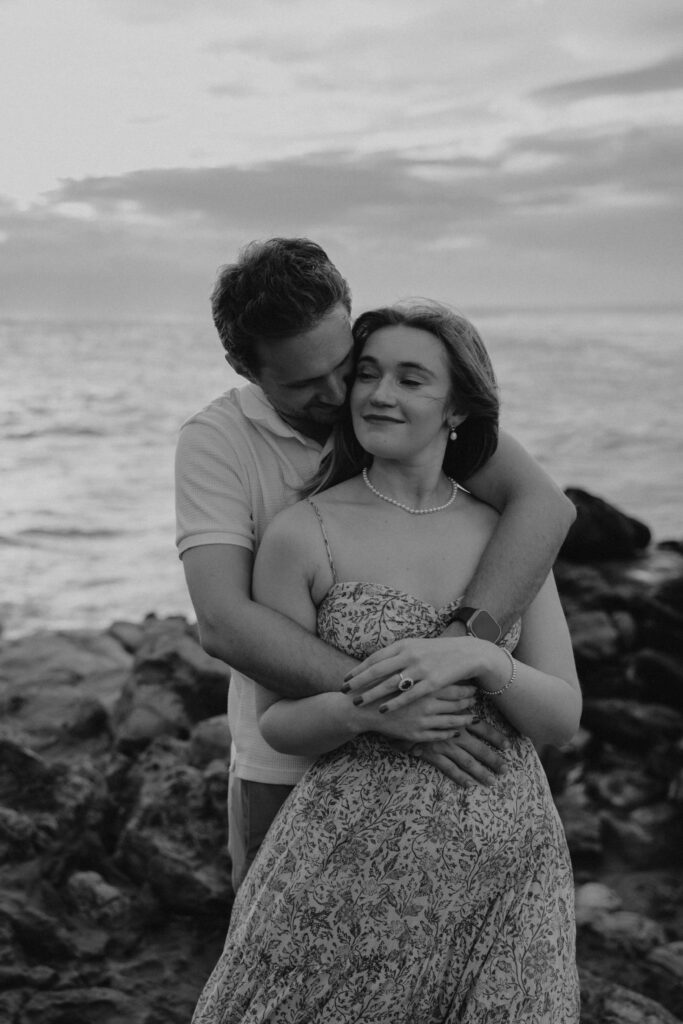 Black and white image of a couple during their beach engagement photoshoot