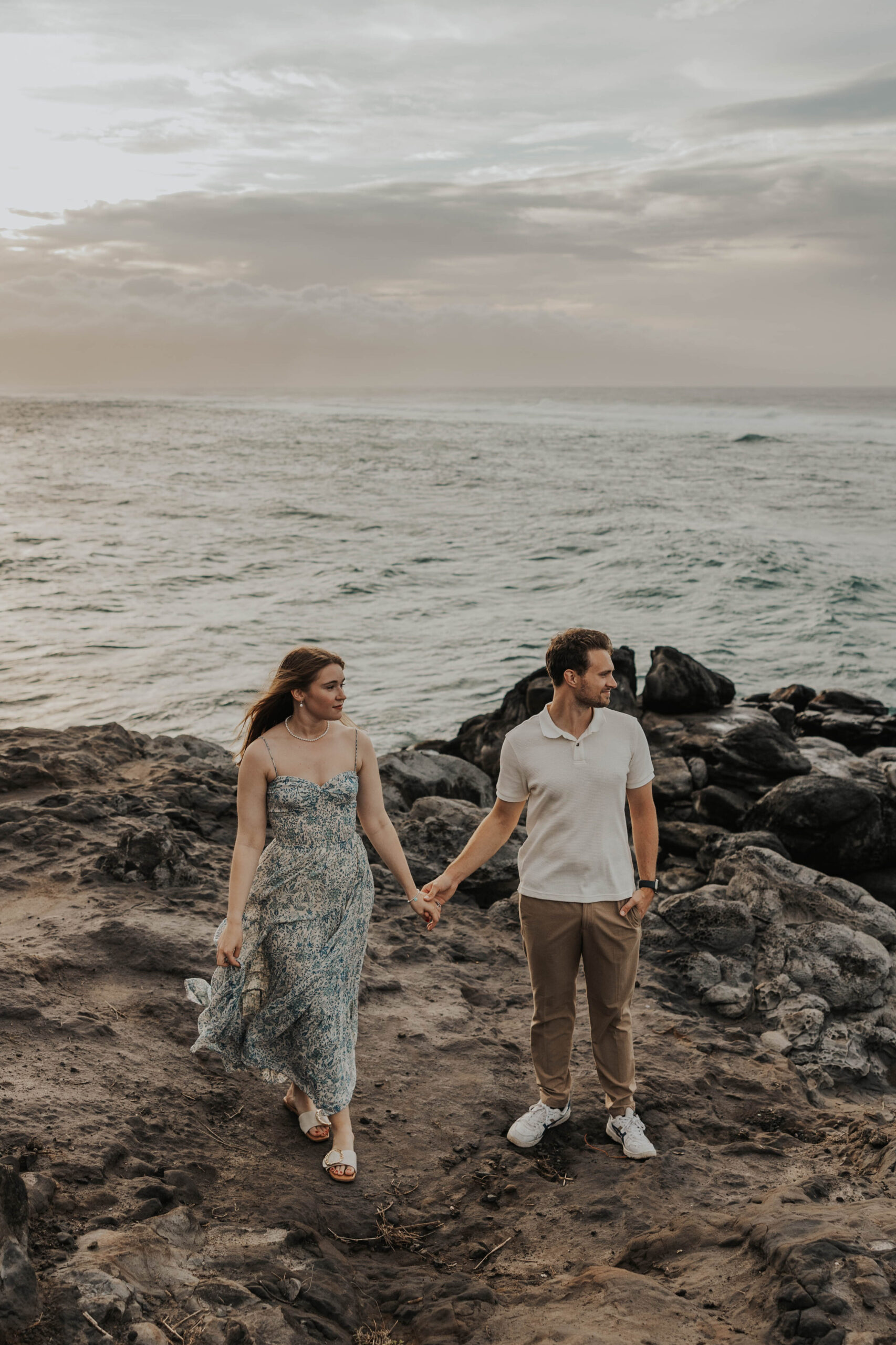 Couple holding hands in front of the ocean in Maui, Hawaii