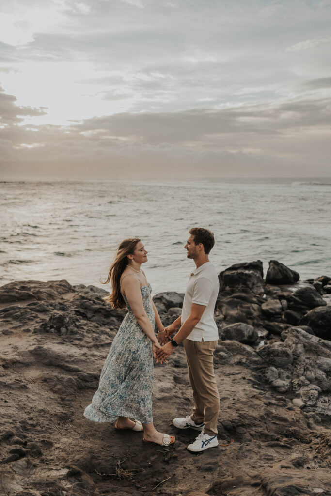 Couple holding hands in front of the ocean in Maui, Hawaii