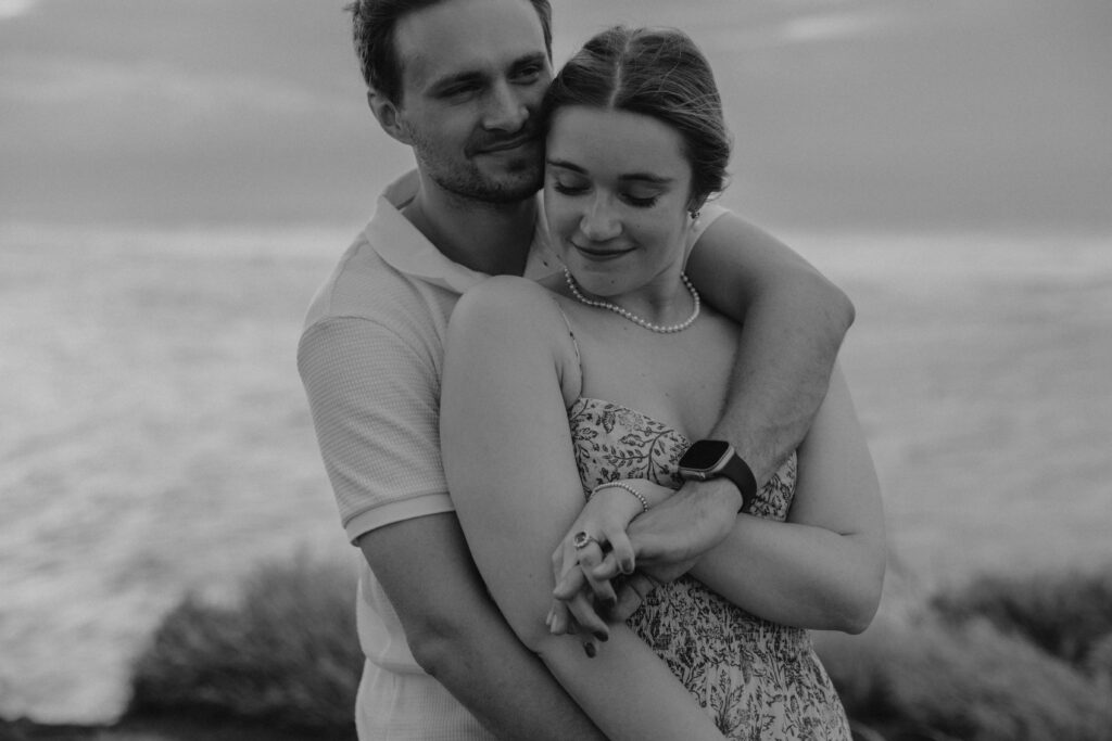 Black and white image of a couple during their beach engagement photoshoot