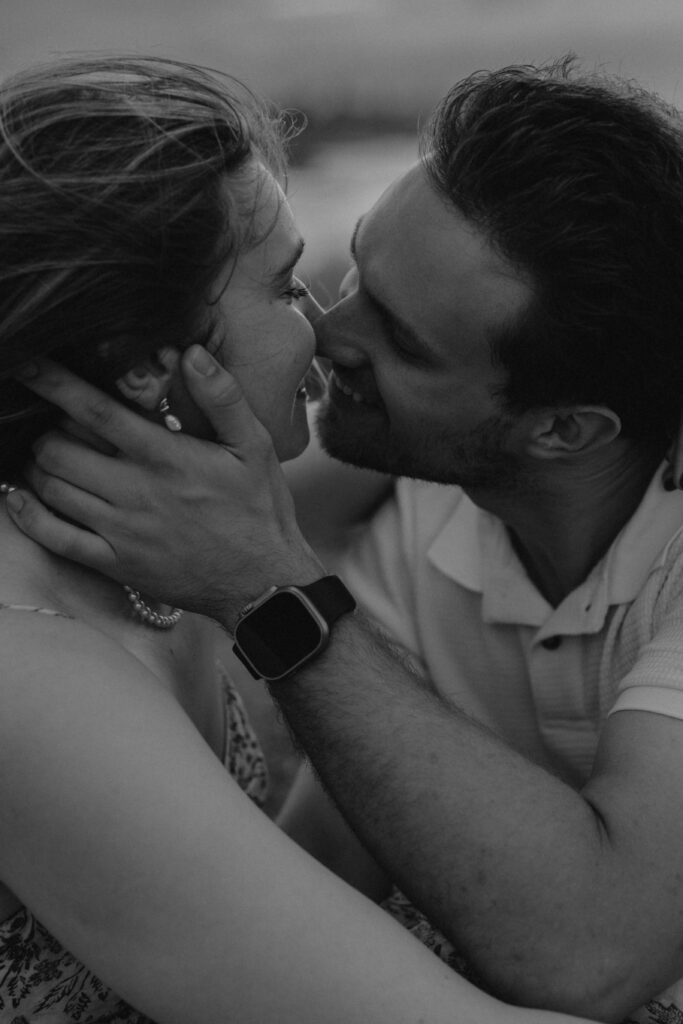 Black and white image of a couple during their beach engagement photoshoot