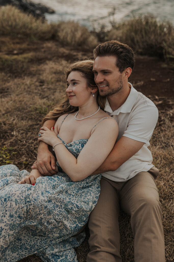 Couple sitting together on a beach in Maui, Hawaii