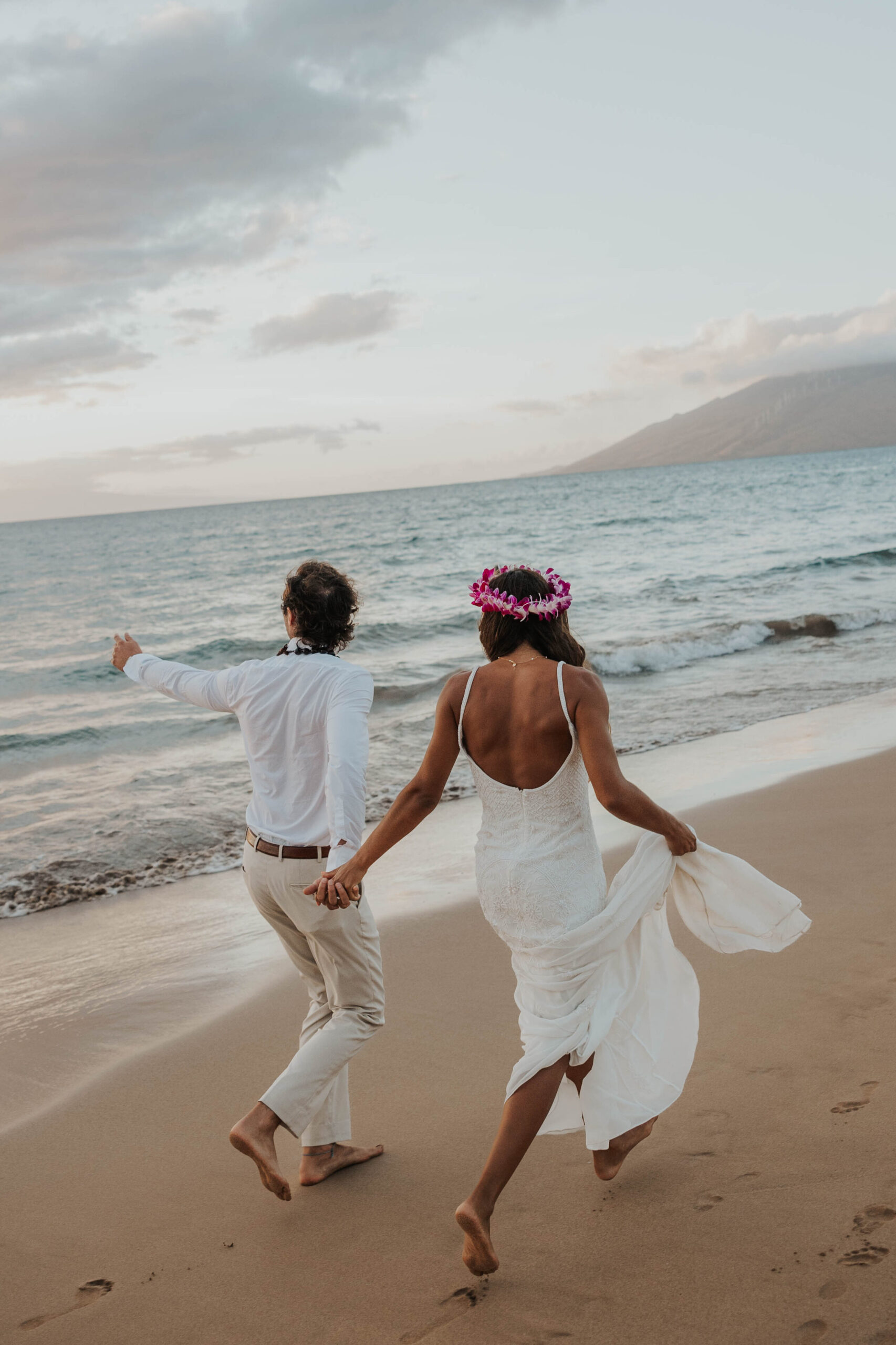 Couple chasing waves during their Maui beach elopement