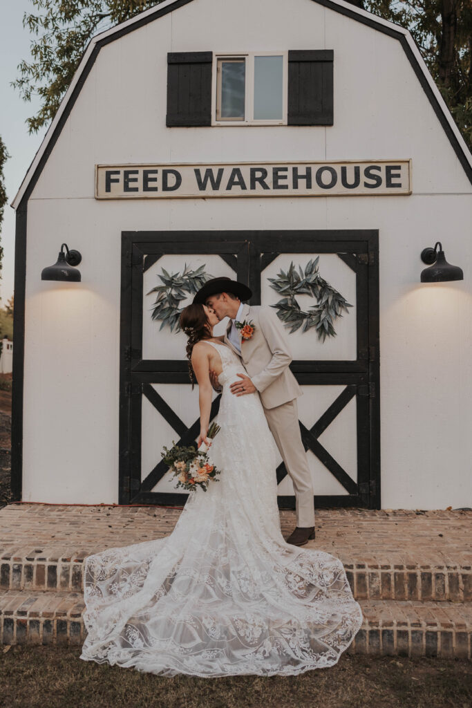 Couple in front of a barn-style building at their wedding in Arizona