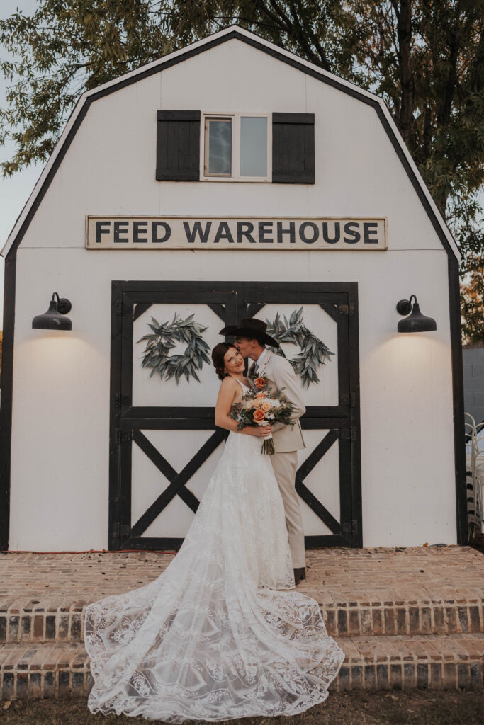 Couple in front of a barn-style building at their wedding in Arizona