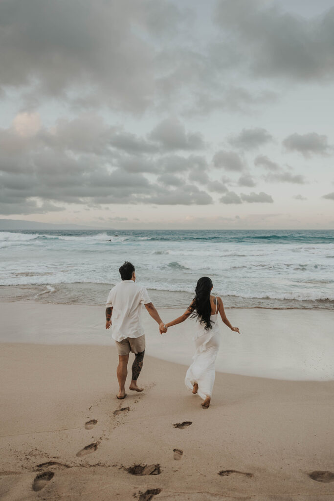 couple playing in the ocean for photoshoot