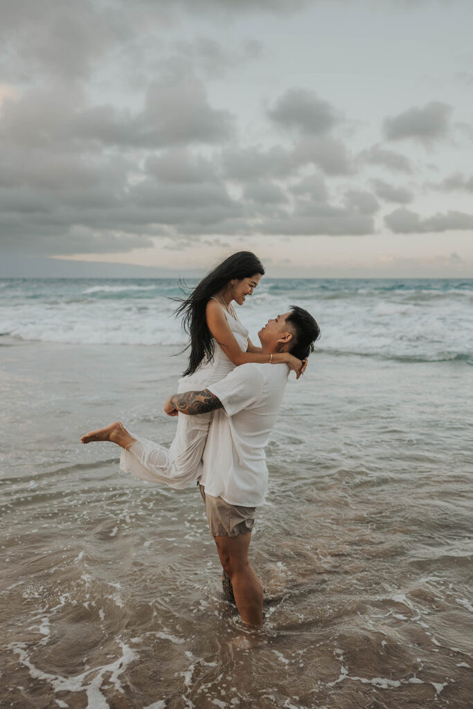 couple playing in the ocean for photoshoot