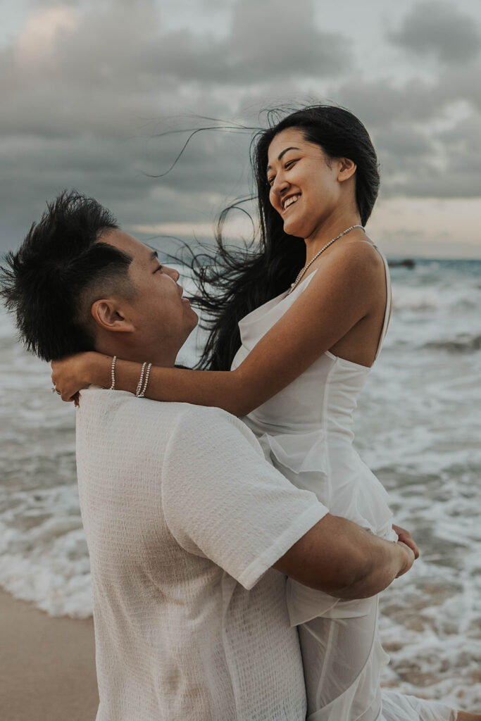 couple playing in the ocean for photoshoot