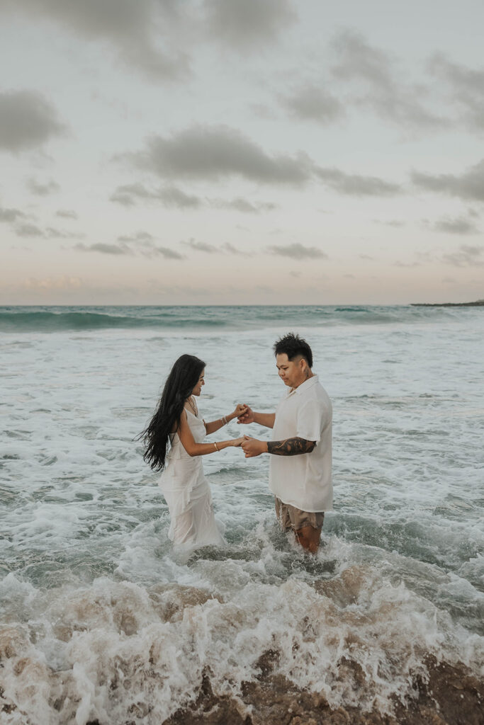 couple playing in the ocean for photoshoot