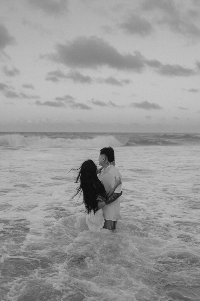 couple playing in the ocean for photoshoot