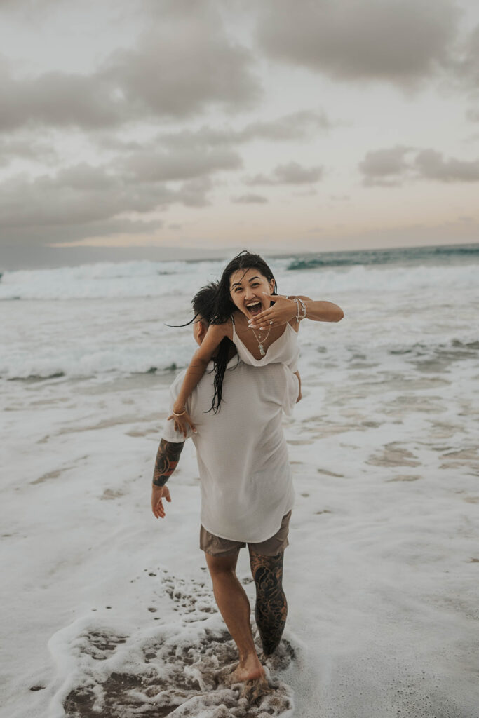 playful engagement pictures on the beach