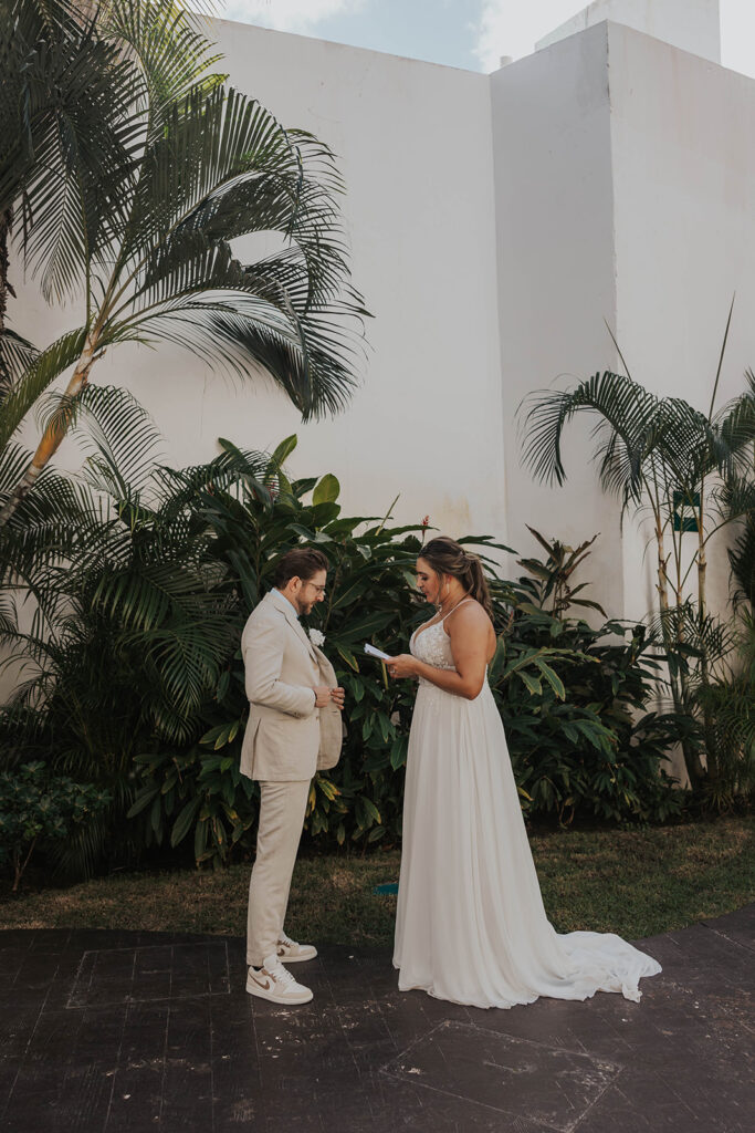 bride and groom sharing private vows in front of palm trees