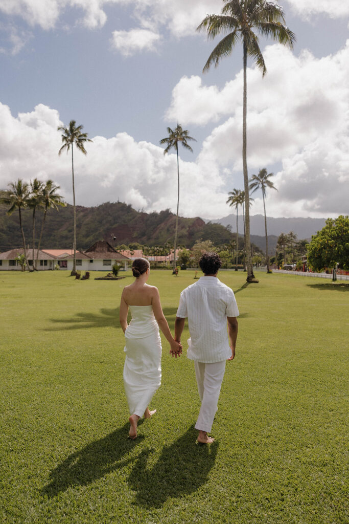 bride and groom walking and holding hands in maui