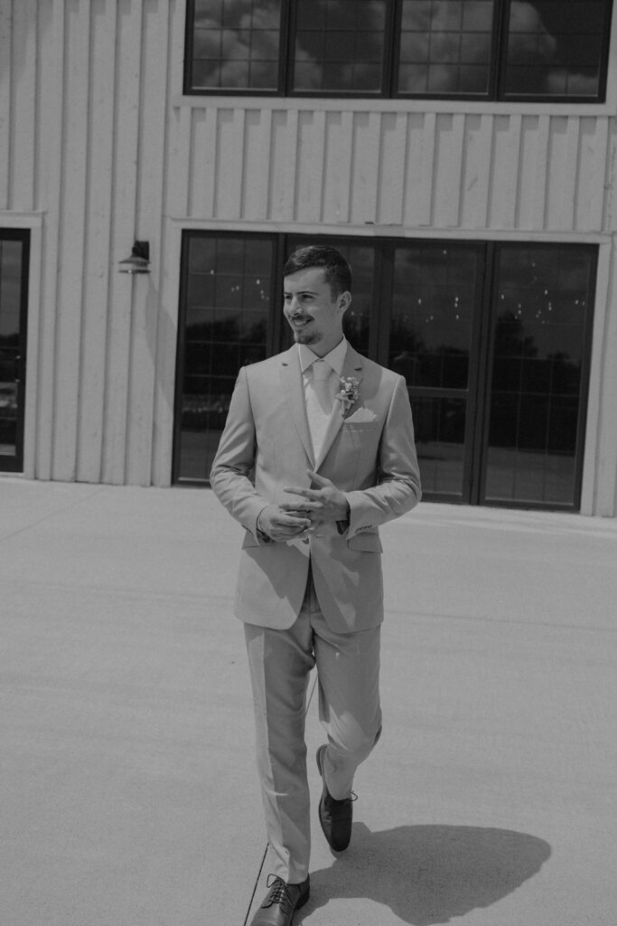groom wedding photos in front of barn