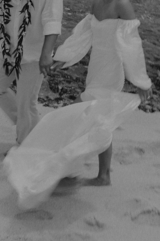bride and groom holding hands and running on the beach