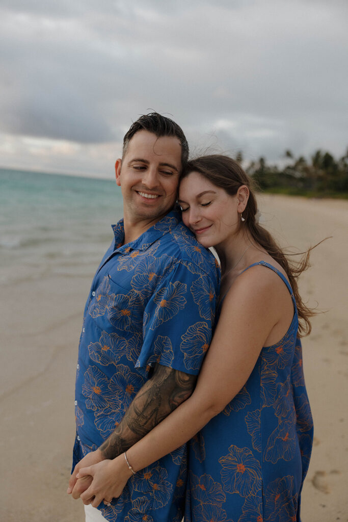 couple smiling while standing on the beach