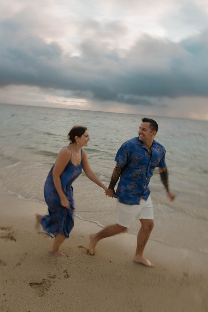 couple holding hands and running on the beach blurry photo