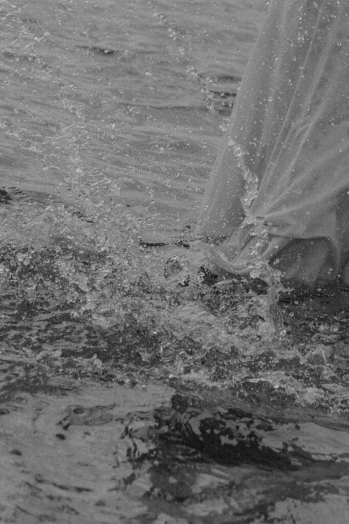 playful candid couples photo playing in the ocean and splashing water