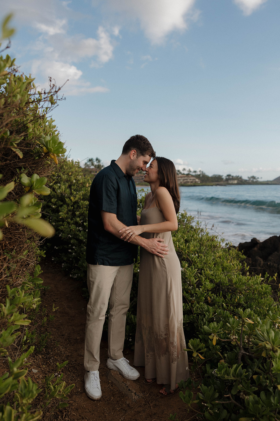 a couple posing on a pathway leading to the beach, captured by a Maui proposal photographer