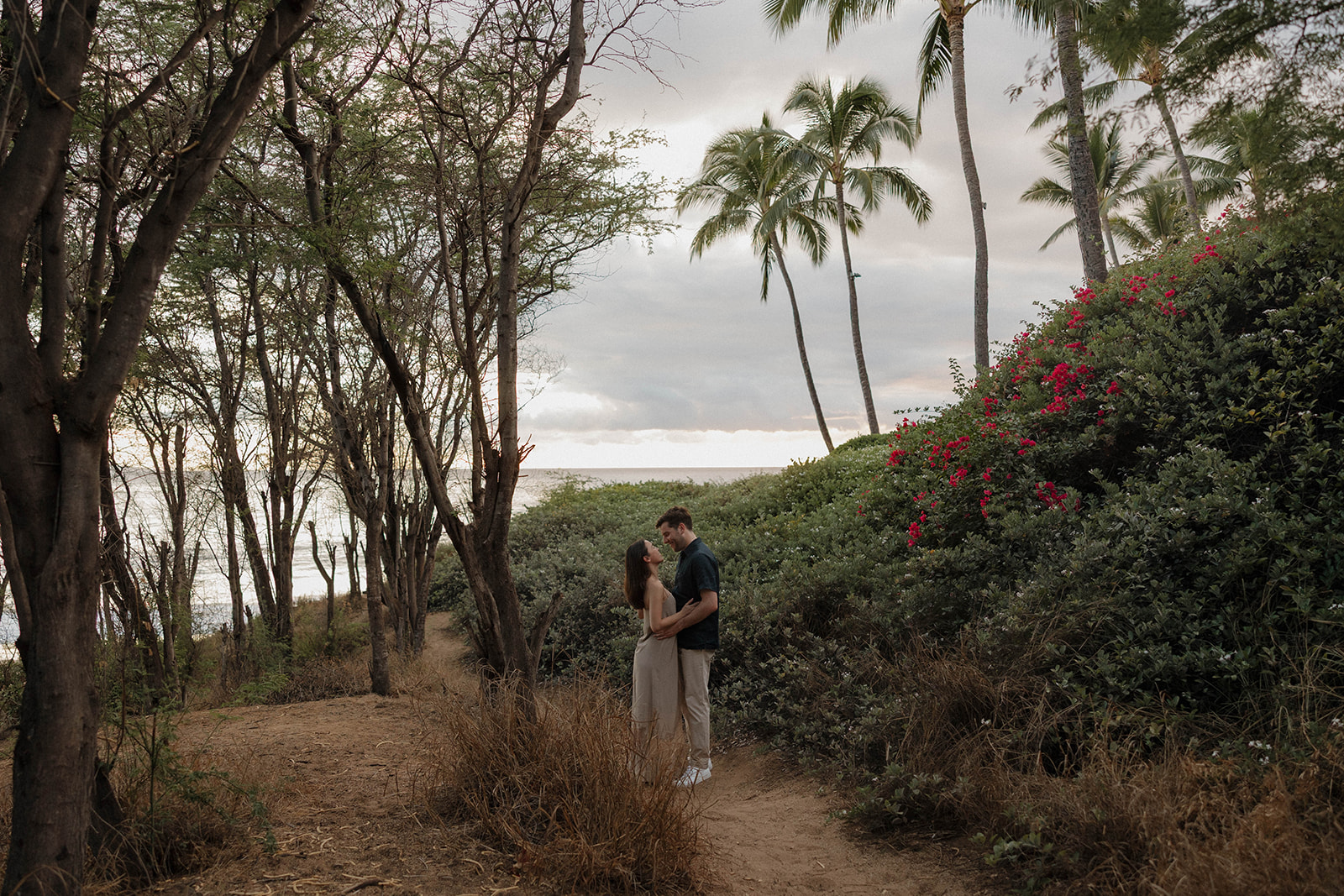 a couple holding each other on the path that leads down to the beach in Maui