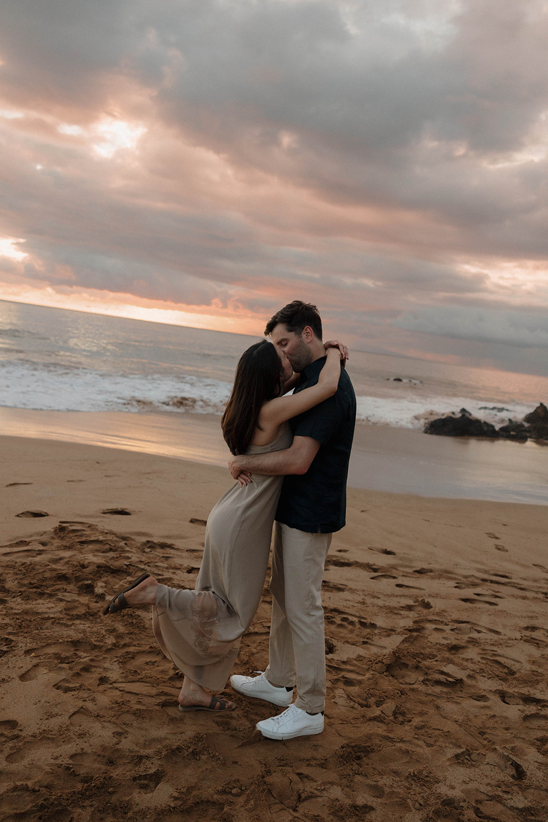 a couple kissing on the beach during sunset at one of Maui's best engagement photo locations
