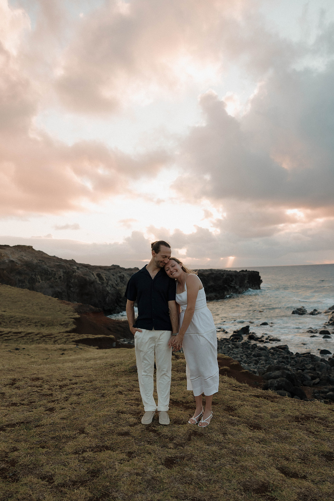a couple standing on the coast of Maui after their engagement