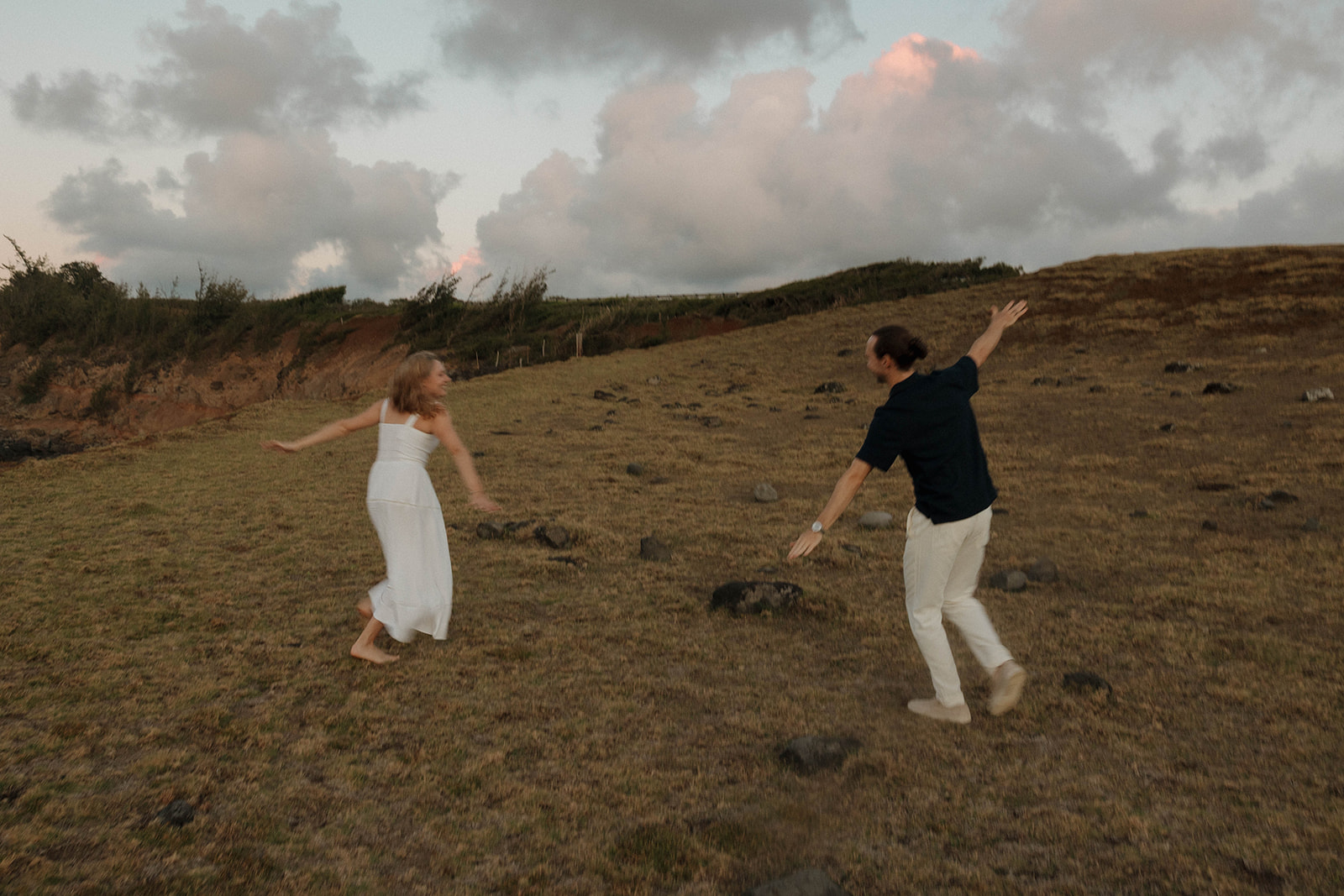 a couple running around with their arms ups, having fun in Maui 
