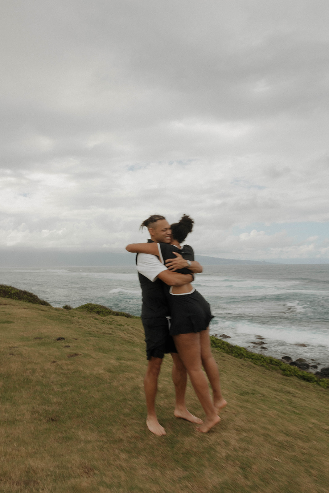 a man picking up a woman and spinning her after he proposed in Maui 
