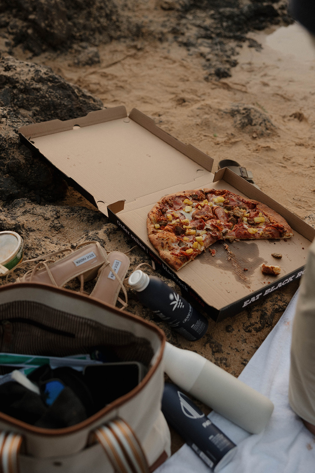 a newly engaged couples pizza picnic after their proposal in Maui