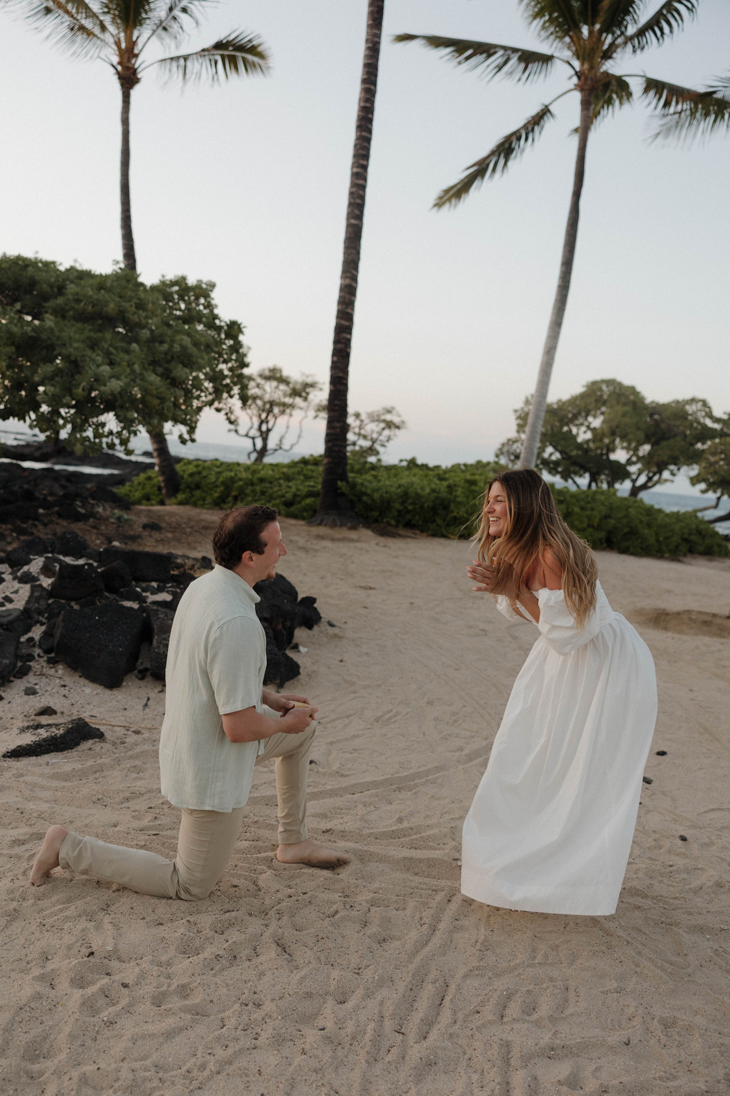 a man proposing to a woman on a beach in Hawaii
