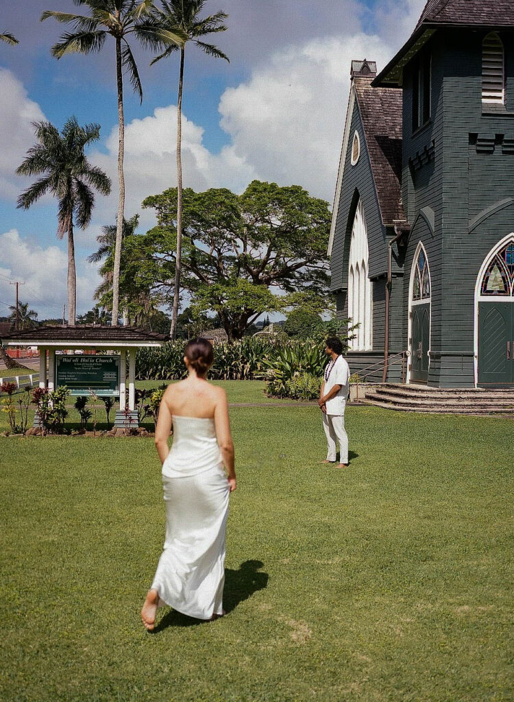 A couple walking around their venue in Maui while filming a Super 8 wedding video.