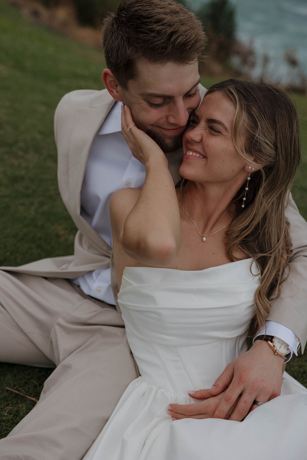 A intimate detail photo of the bride and groom sitting on the grass during their wedding portraits.