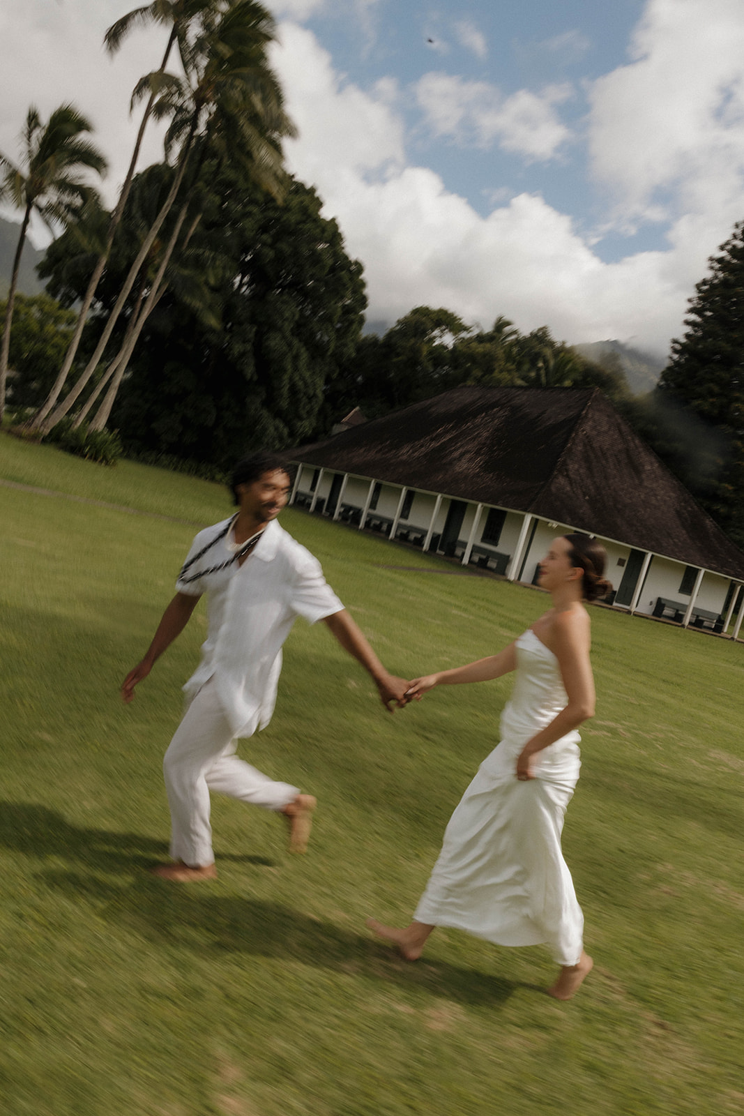 Newlyweds running on a grassy lawn after their micro wedding in Kauai, a stunning motion blur shot for a cinematic touch to their day.