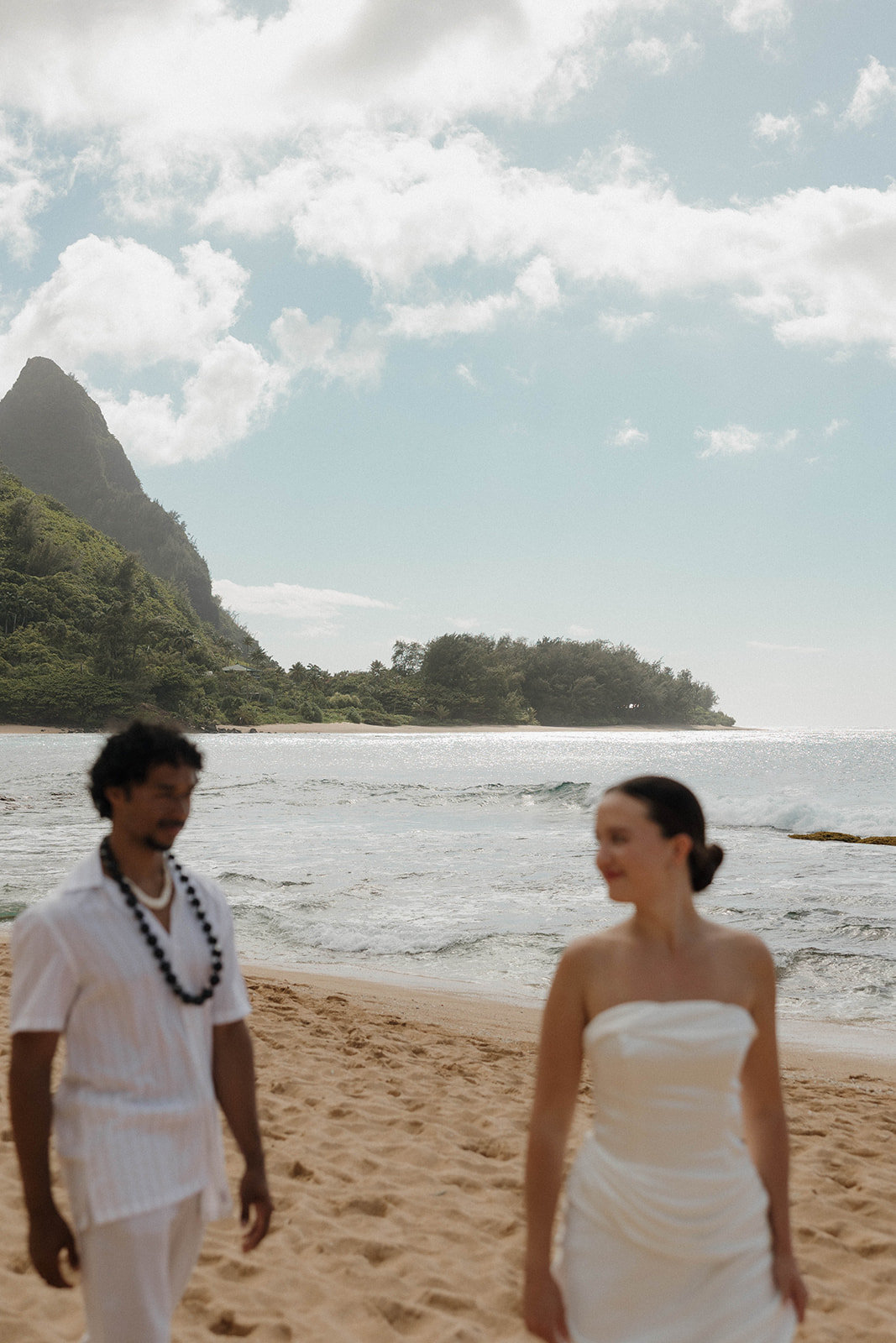 The bride and groom standing on the beach after their micro wedding in Kauai
