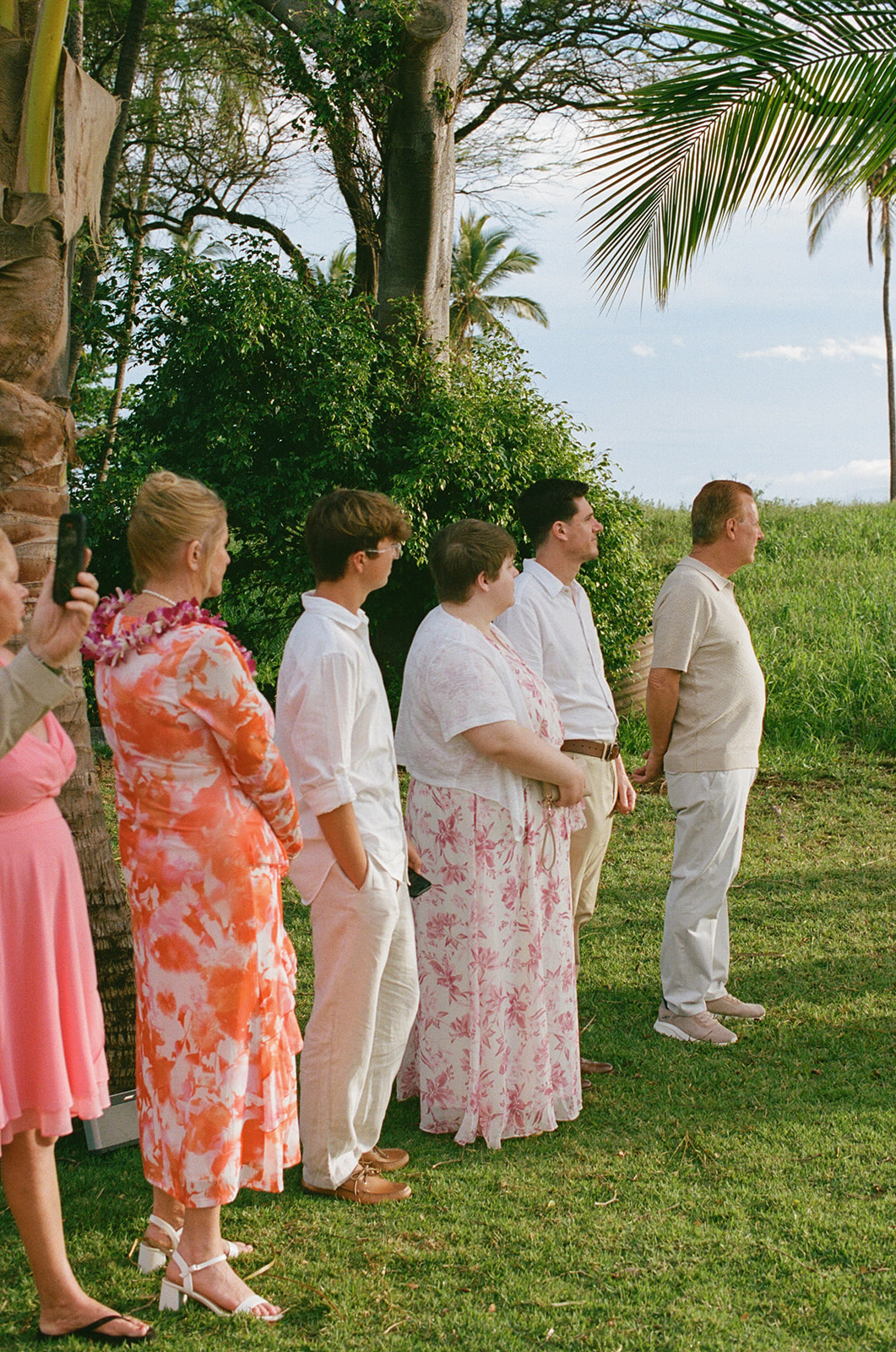 Small group of guests watching a Maui elopement ceremony at golden hour
