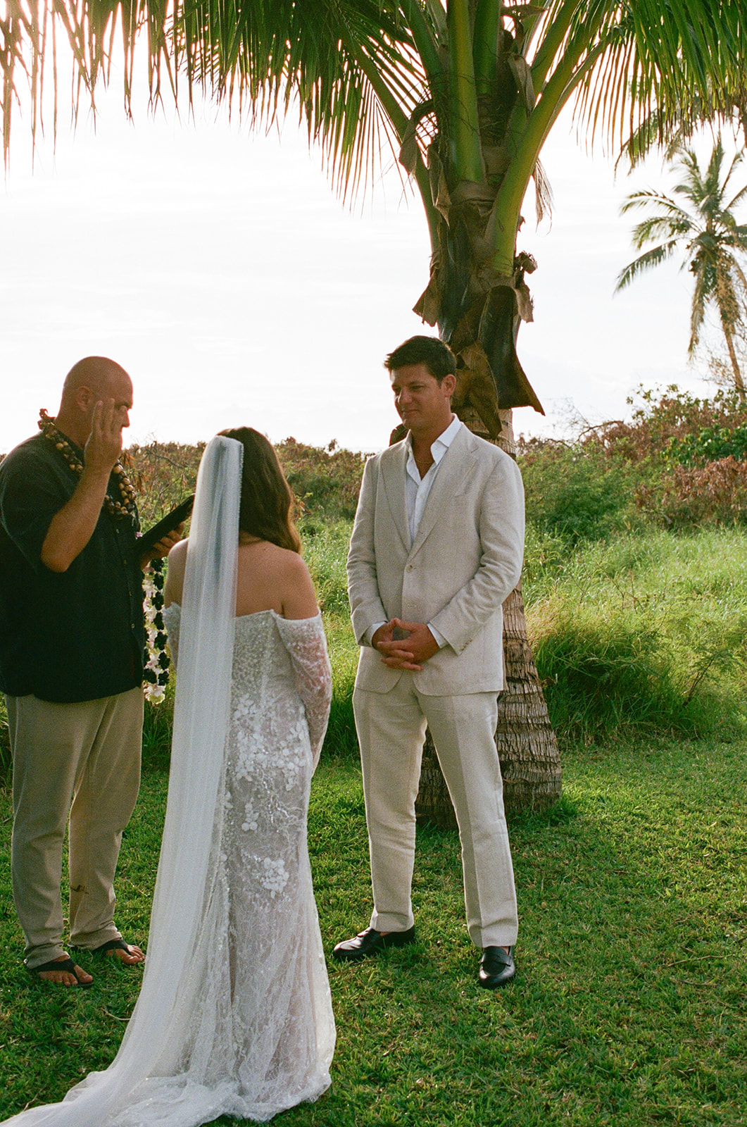 Groom gazing at bride during outdoor Hawaii wedding ceremony
