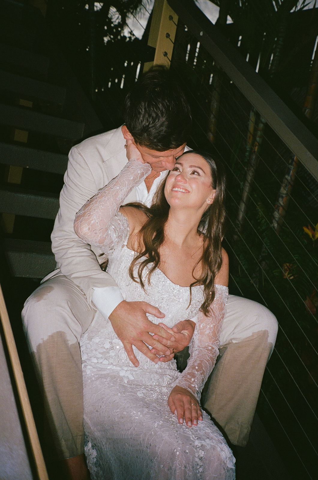 Bride gazing up at groom while sitting together on outdoor stairs during their Maui elopement
