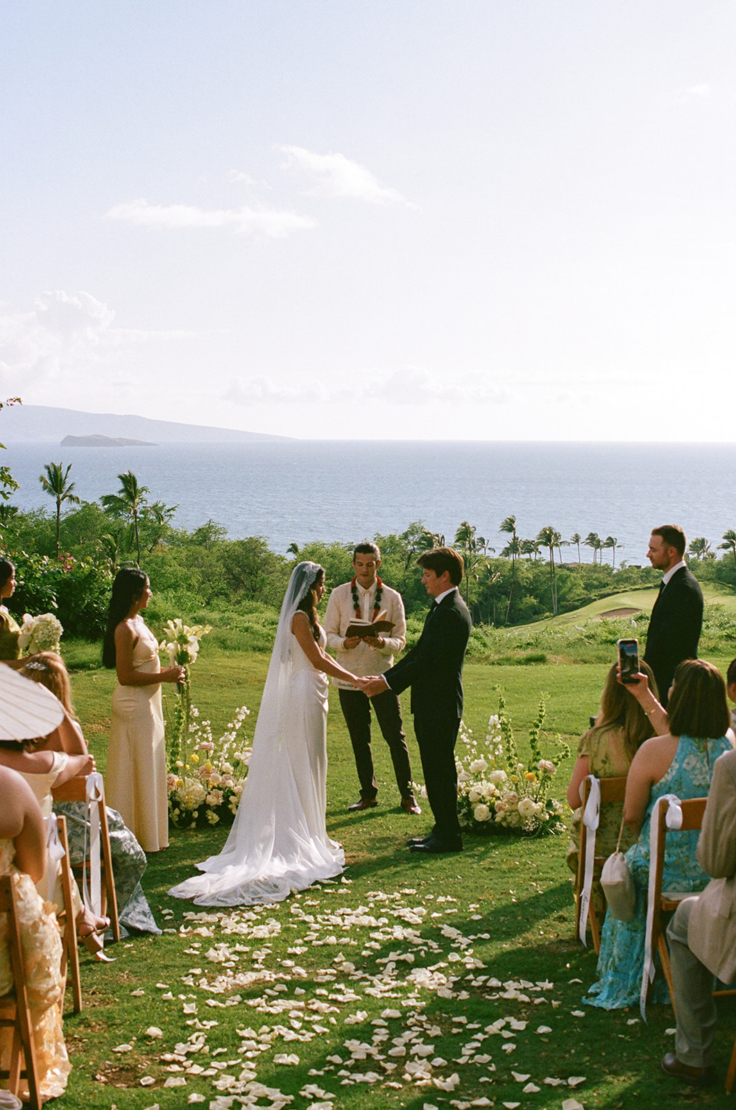 Bride and groom holding hands at the altar with the officiant reading their vows
