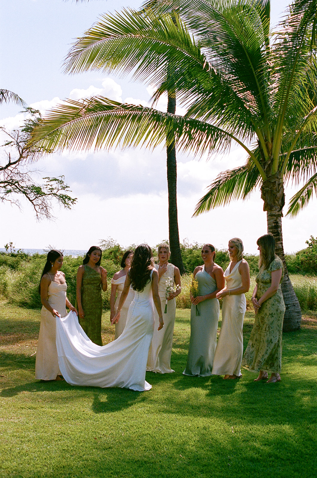 Wedding film photography scene of the bride and bridesmaids gathered together under palm trees

