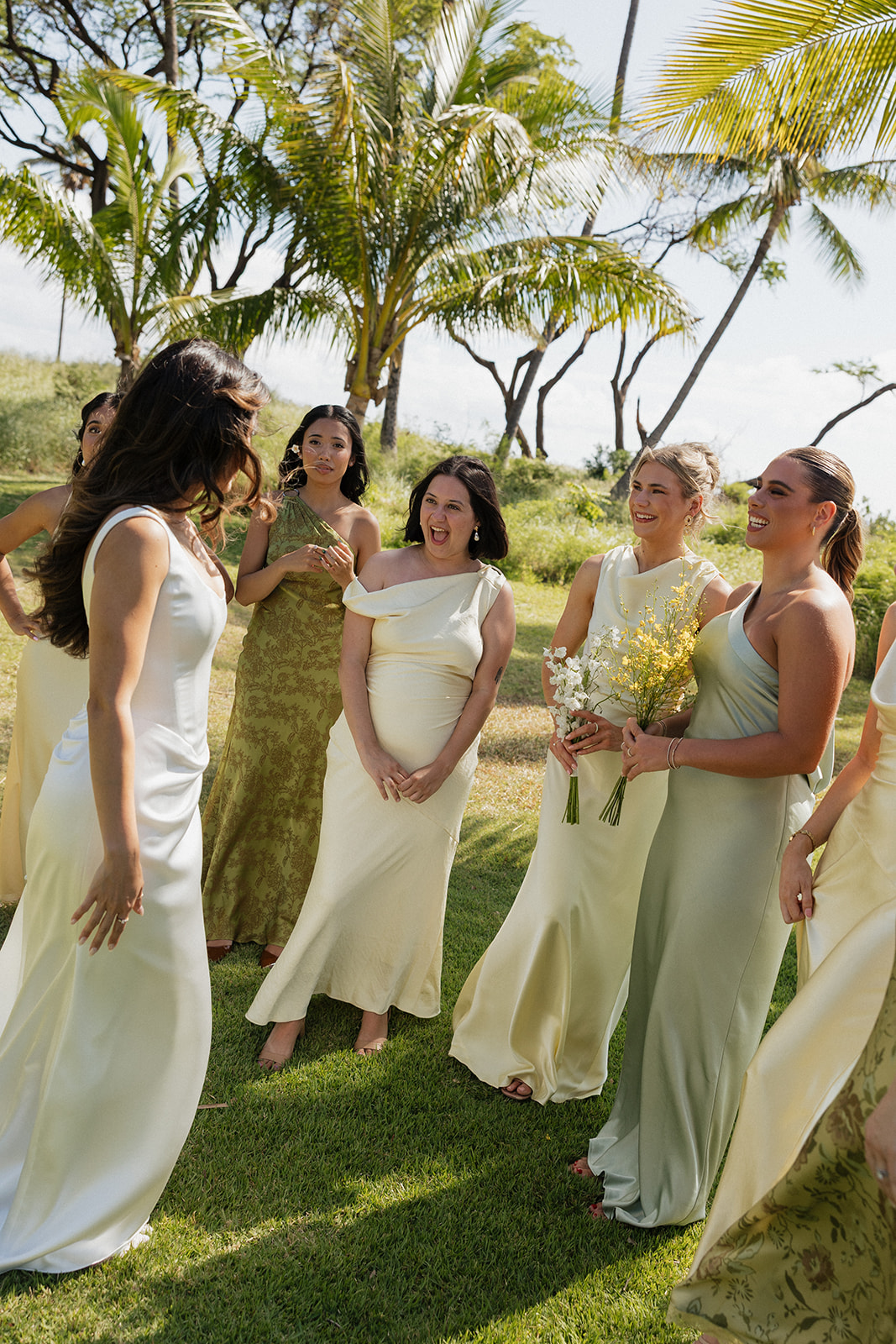 Wedding film photography of bridesmaids laughing together on the lawn before the ceremony
