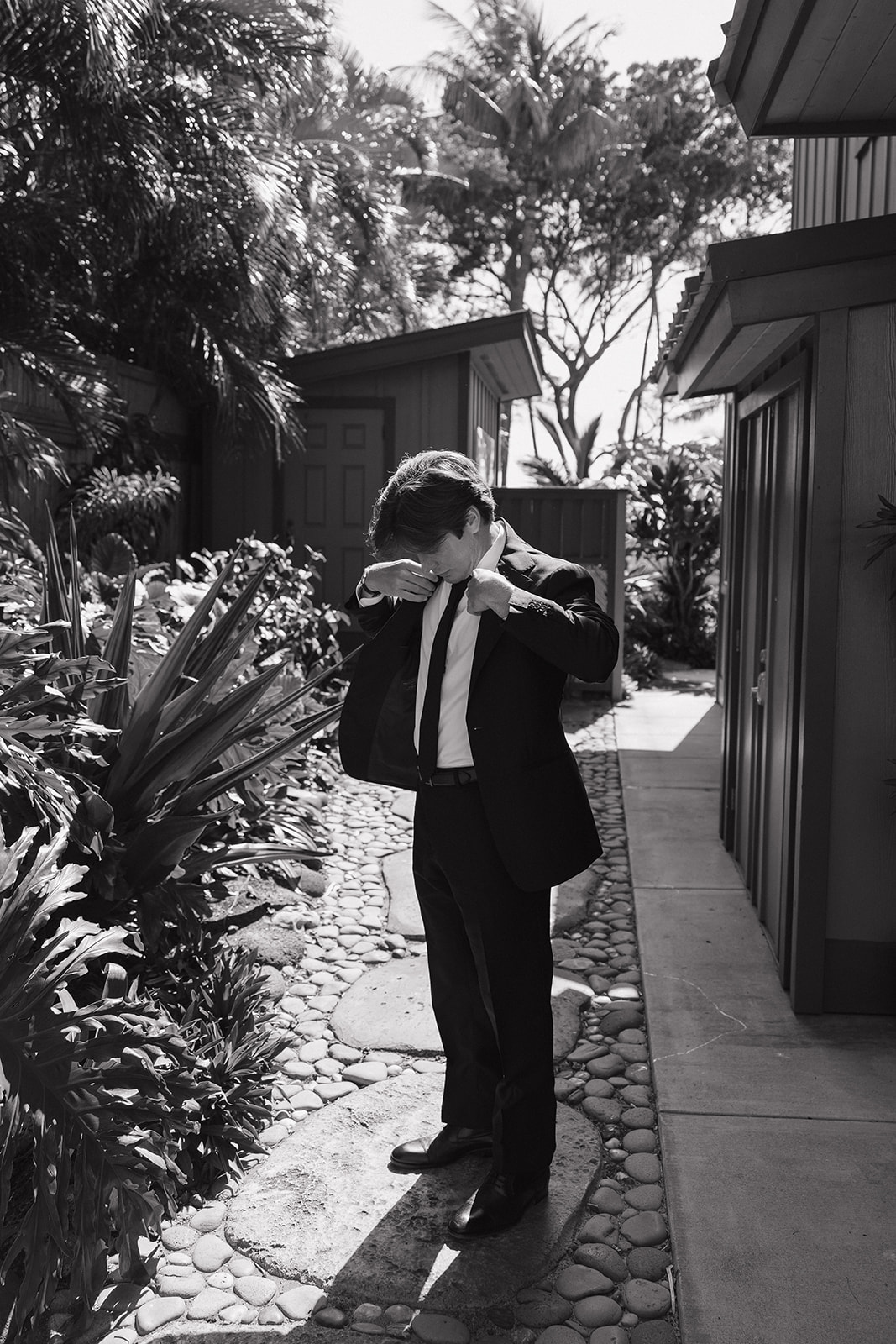 Wedding film photography portrait of the groom adjusting his jacket before the ceremony
