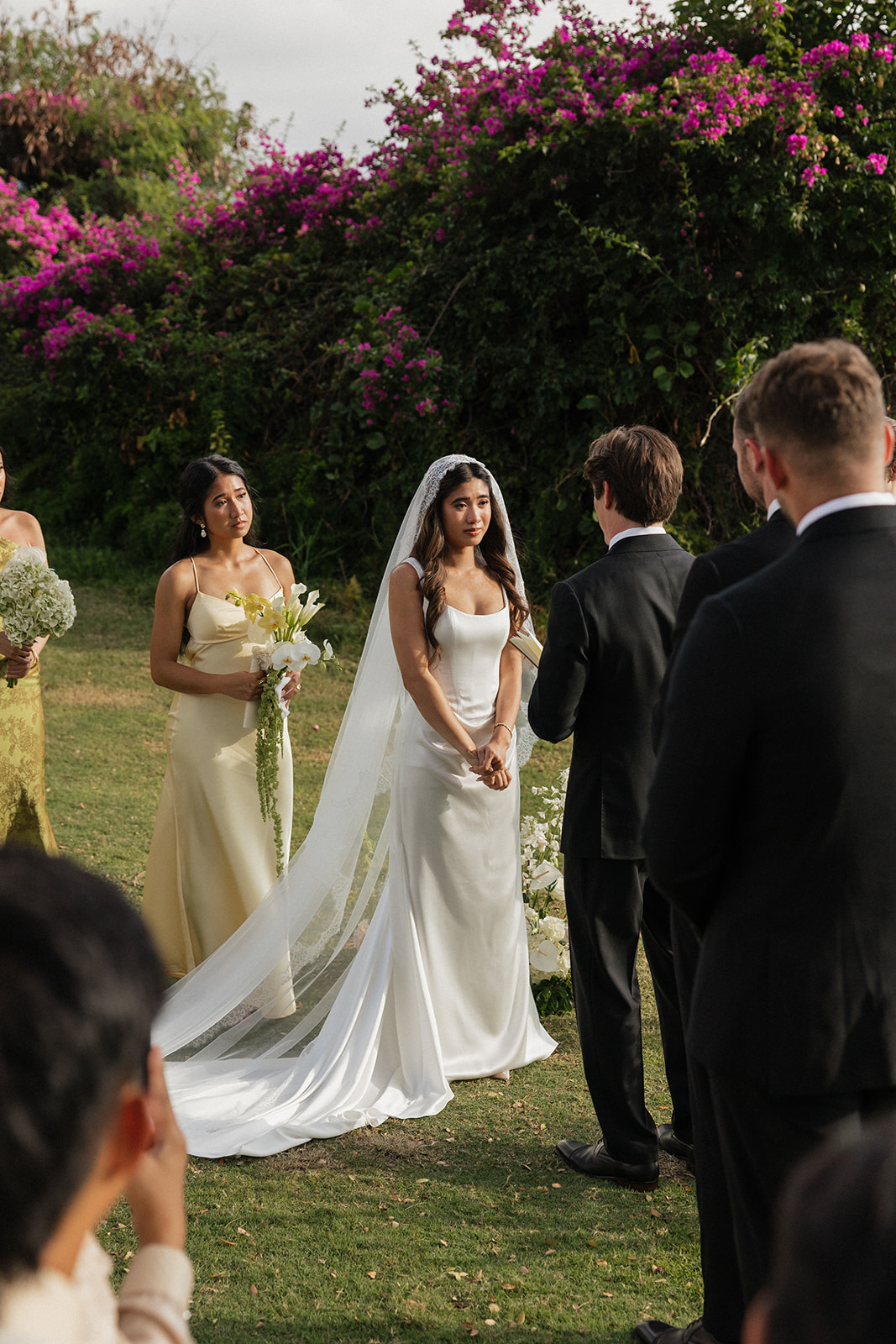 Bride standing teary-eyed at the altar as her groom faces her during the vows
