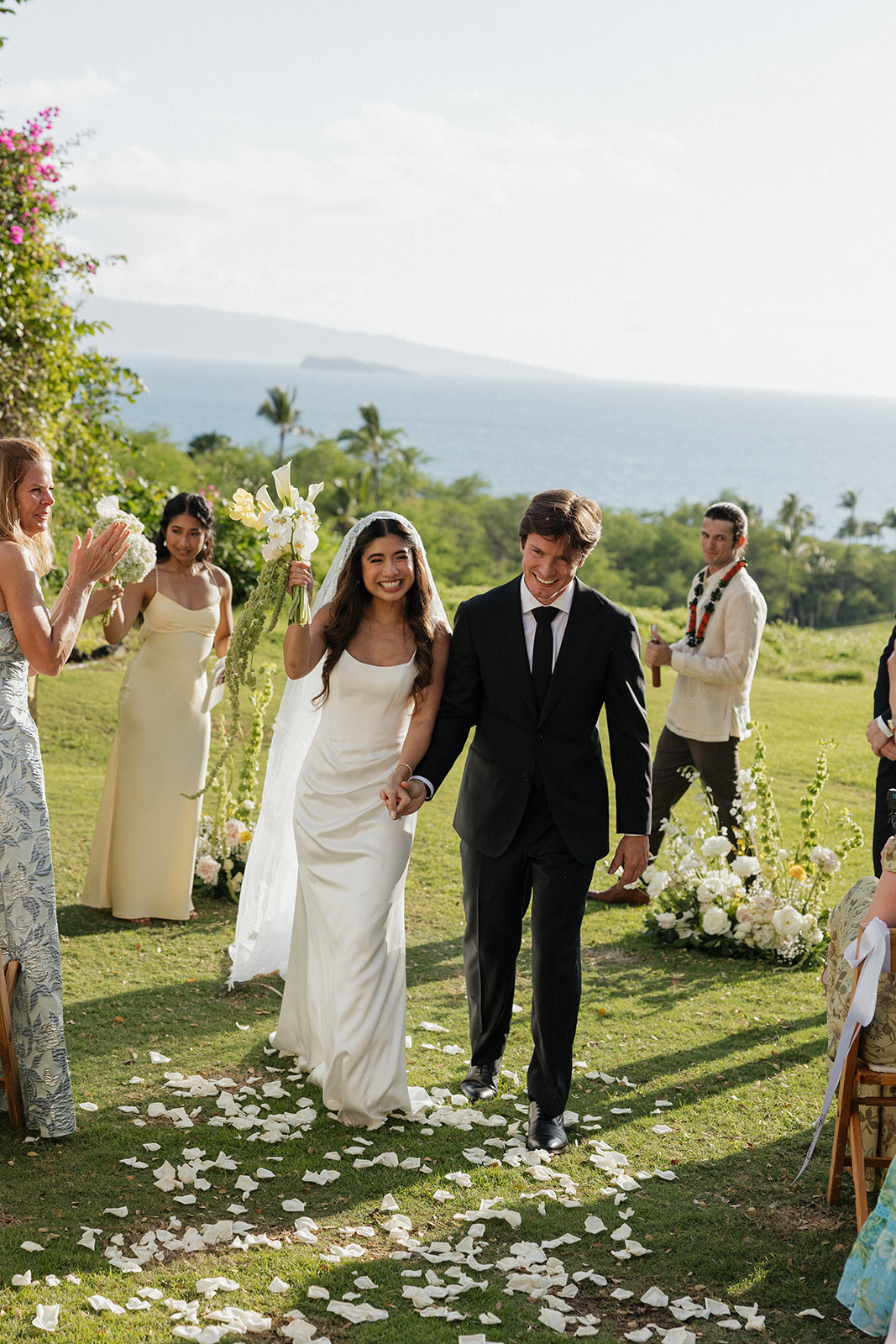 Wedding film photography of the newlyweds smiling as they walk back up the aisle after their ceremony
