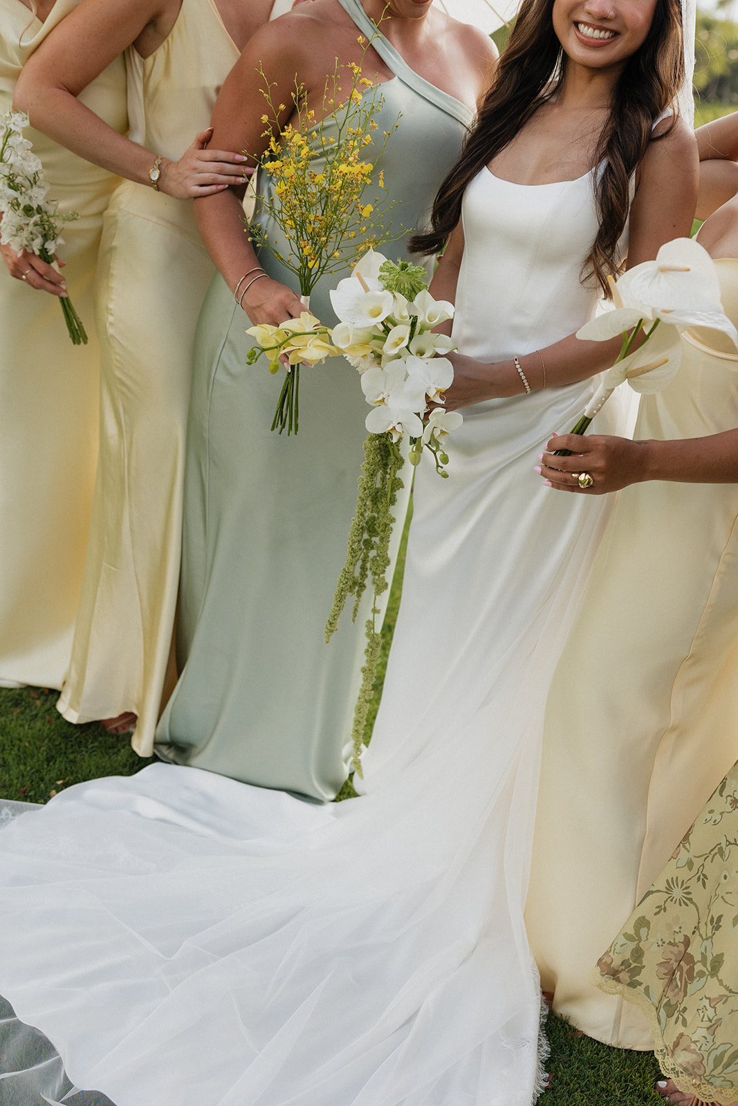 Close-up of bridesmaids and the bride holding their bouquets together before the ceremony
