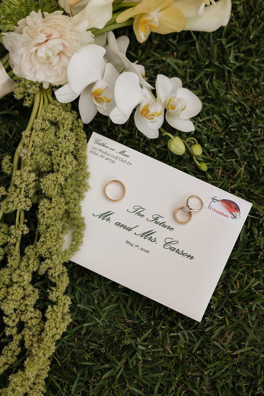 Envelope addressed to "The Future Mr. and Mrs. Carson" beside wedding rings and orchids