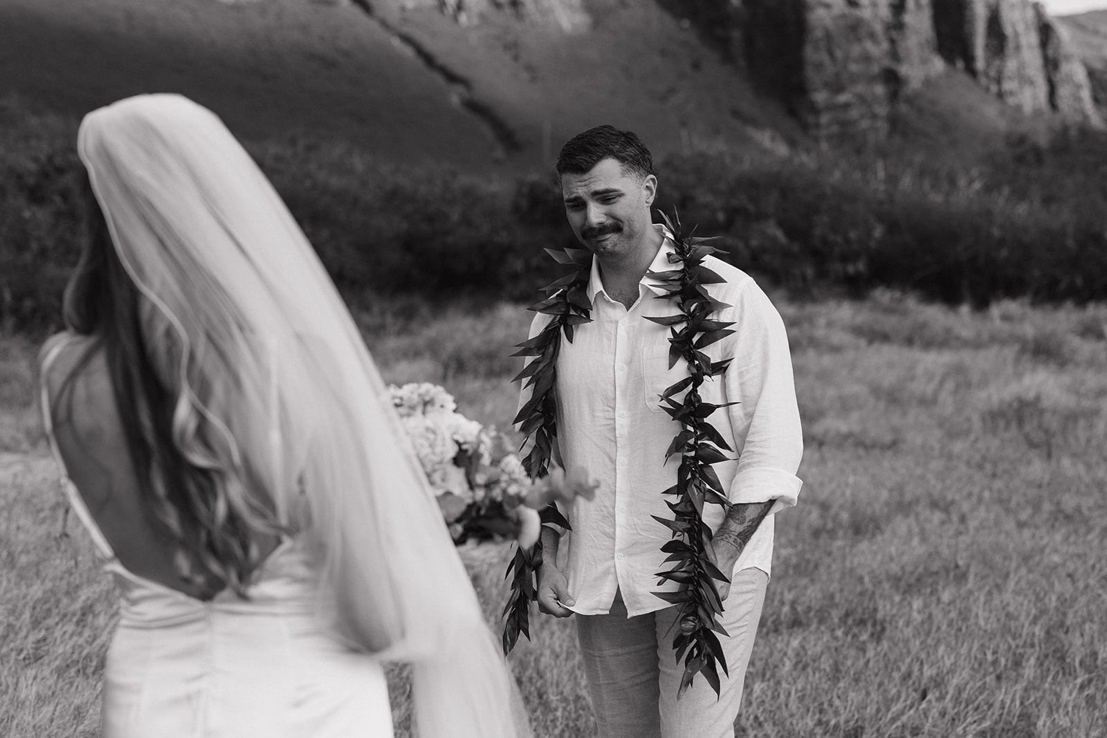 Black and white candid of the groom getting emotional as he sees his bride for the first time.